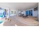 Expansive outdoor patio with lounge chairs, white pillars, and views of the pool and waterfront at 12650 7Th E St, Treasure Island, FL 33706