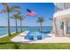 The outdoor area boasts a luxurious pool, bar seating, beautiful water views, and perfectly placed palms at 12650 7Th E St, Treasure Island, FL 33706