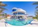 Beautiful modern home boasts a stunning pool with artistic sculptures and tropical landscaping at 12650 7Th E St, Treasure Island, FL 33706