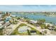 Aerial view of property near a waterfront community with calm waters, palm trees, and clear skies at 13313 3Rd E St, Madeira Beach, FL 33708