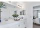 Clean, modern bathroom featuring double sinks, white cabinets, and elegant fixtures at 13434 Tropical Breeze Way, Hudson, FL 34669