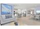 Bright open-concept living room with modern furnishings, leading to a kitchen with a central island and stainless steel appliances at 13434 Tropical Breeze Way, Hudson, FL 34669