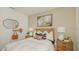 Cozy bedroom features stylish decor, including a framed tree print, mirror, and lamps, creating a warm, inviting atmosphere at 13458 Tropical Breeze Way, Hudson, FL 34669
