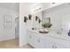 Bathroom with double vanity, framed mirror, white cabinets, quartz countertop, and a glass enclosed shower at 13478 Tropical Breeze Way, Hudson, FL 34669