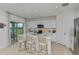 Bright kitchen with white cabinets, stainless steel appliances, a center island, and sliding door access to outdoor space at 13478 Tropical Breeze Way, Hudson, FL 34669