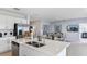 Modern kitchen island featuring stainless steel sink, white countertops, and view to the dining and living area at 13478 Tropical Breeze Way, Hudson, FL 34669
