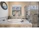 Bright bathroom featuring a soaking tub and a separate glass-enclosed shower at 1509 Amarone Pl, Lutz, FL 33548