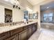 Bathroom vanity with granite countertops, double sinks, and a walk-in closet at 1509 Amarone Pl, Lutz, FL 33548