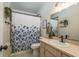 Bathroom with blue floral shower curtain, vanity and ample lighting at 15856 49Th N St, Clearwater, FL 33762