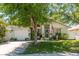 Charming single Gathering home with manicured lawn, flowering trees, and front-facing two car garage at 15856 49Th N St, Clearwater, FL 33762
