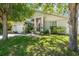 Inviting home exterior with lush lawn, blossoming trees and decorative garden accents at 15856 49Th N St, Clearwater, FL 33762