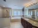 Large bathroom with dual sinks, granite countertops, tile floor, and large soaking tub at 16127 Churchview S Dr, Lithia, FL 33547