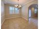 Well-lit dining room with tile flooring, an elegant chandelier, and a large window with plantation shutters at 16127 Churchview S Dr, Lithia, FL 33547