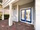 The entrance features a blue double door, red brick, and white pillars for a welcoming entryway at 16127 Churchview S Dr, Lithia, FL 33547