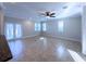 A bright, open living room with tile flooring, a ceiling fan, and French doors leading to the outside at 16127 Churchview S Dr, Lithia, FL 33547