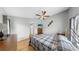 Bright bedroom features wood floors, vaulted ceiling, ceiling fan, and a television above a wooden dresser at 1613 E Del Webb Blvd, Sun City Center, FL 33573