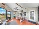 Bright sunroom with terracotta floors, vaulted ceilings, ceiling fan, and a billiard table near the picture window at 1613 E Del Webb Blvd, Sun City Center, FL 33573