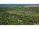 Aerial view of home in a heavily wooded area, marked with an arrow at 16420 Iola Woods Trl, Dade City, FL 33523
