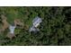 Aerial view of the home nestled among dense trees at 16420 Iola Woods Trl, Dade City, FL 33523