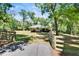 View of metal barn and fenced paddock area, complemented by a gated driveway entrance at 16420 Iola Woods Trl, Dade City, FL 33523