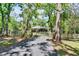 Scenic driveway leading to barn and paddock, bordered by mature trees at 16420 Iola Woods Trl, Dade City, FL 33523