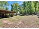 Metal barn providing shelter and storage for equipment, situated on a spacious, fenced property with trees at 16420 Iola Woods Trl, Dade City, FL 33523