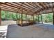 Spacious barn interior with concrete floor, wooden beams, and fence offering shelter for livestock and equipment at 16420 Iola Woods Trl, Dade City, FL 33523