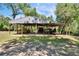 Large metal barn offering ample covered storage space for equipment and livestock, with an adjacent paddock at 16420 Iola Woods Trl, Dade City, FL 33523