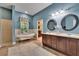 Bright bathroom with double sinks, a standalone tub, walk-in shower, and plenty of storage at 16420 Iola Woods Trl, Dade City, FL 33523