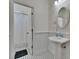 Classic bathroom with pedestal sink, wainscoting, and black and white mosaic tile floor at 16420 Iola Woods Trl, Dade City, FL 33523