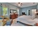 Bedroom with ceiling fan, carpet, blue walls, seating area, and ensuite bathroom at 16420 Iola Woods Trl, Dade City, FL 33523