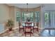 Cozy breakfast nook features a round table, natural light, and serene backyard views at 16420 Iola Woods Trl, Dade City, FL 33523