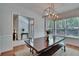 Formal dining room with modern chandelier, long dining table with bench, and view of the foyer at 16420 Iola Woods Trl, Dade City, FL 33523