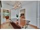 Formal dining room with modern chandelier, dining table with bench, and view to kitchen and living room at 16420 Iola Woods Trl, Dade City, FL 33523