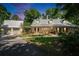 Beautiful home with metal roof and lush landscaping; illuminated by a stunning sunset at 16420 Iola Woods Trl, Dade City, FL 33523