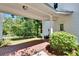 Inviting front porch with brick flooring, classic columns, and a view of the lush greenery of the front yard at 16420 Iola Woods Trl, Dade City, FL 33523