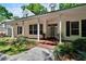 Inviting front porch with columns, ceiling fan, and well-manicured landscaping at 16420 Iola Woods Trl, Dade City, FL 33523