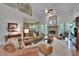 Spacious living room with high ceilings, fireplace, hardwood floors, open concept to the dining room at 16420 Iola Woods Trl, Dade City, FL 33523