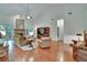 Bright living room featuring vaulted ceilings, hardwood floors, a cozy fireplace, and natural light at 16420 Iola Woods Trl, Dade City, FL 33523