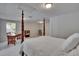 Spacious main bedroom with neutral carpet, with a four-poster bed and a view of an office area at 16420 Iola Woods Trl, Dade City, FL 33523