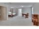 Spacious bedroom features neutral carpet, a four-poster bed, and a view of an office area at 16420 Iola Woods Trl, Dade City, FL 33523