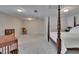 Spacious main bedroom with neutral carpet, and a four-poster bed, a rocker, and a bookshelf at 16420 Iola Woods Trl, Dade City, FL 33523