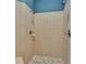 Walk-in shower with two shower heads, tile floor, and neutral colored tiles at 16420 Iola Woods Trl, Dade City, FL 33523