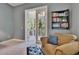 Sitting area that features French doors to a covered balcony with a ceiling fan, a chair, and built-in shelving at 16420 Iola Woods Trl, Dade City, FL 33523