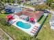 Gorgeous aerial view of a single-Gathering home with a pool, red accents, and well-manicured landscaping at 1650 Springdale Dr, Holiday, FL 34691