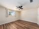 This bedroom has wood-style floors, a window with curtains, and a ceiling fan at 1650 Springdale Dr, Holiday, FL 34691