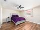 Cozy bedroom with a plush purple bed, ceiling fan, and hardwood floors at 1650 Springdale Dr, Holiday, FL 34691