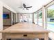 Spacious game room featuring a large table and views of the backyard and pool at 1650 Springdale Dr, Holiday, FL 34691