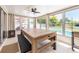 Bright game room with a large table, bench, pool view, and access to the backyard at 1650 Springdale Dr, Holiday, FL 34691