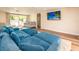 Bright living room with wood floors, large sectional sofa, and a mounted flat screen TV at 1650 Springdale Dr, Holiday, FL 34691